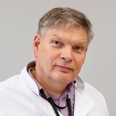Mies valkoisessa lääkärintakissa, kaulalla stetoskooppi